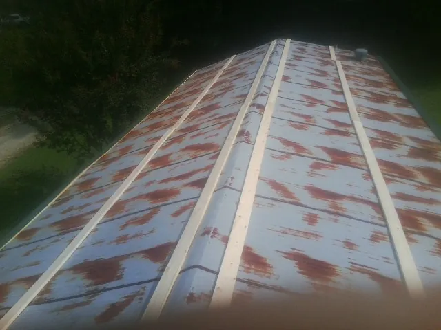 Rusted metal roof panels with new wood purlins before replacement — Storm Damage Roof Repair in Grosse Ile by Roofing Brothers