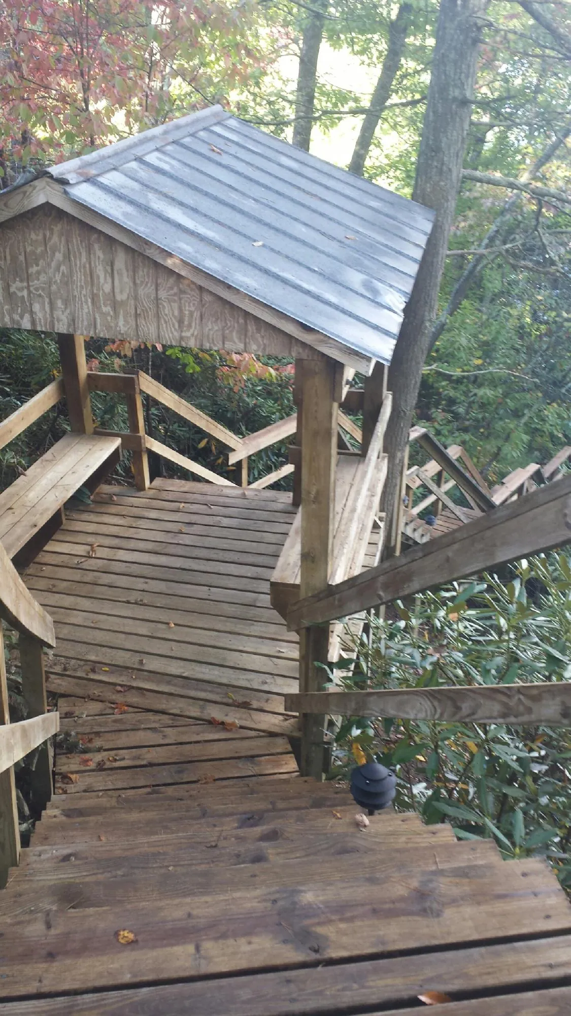 Metal roofed shelter over wooden steps on a wooded walkway — Skylight Repair & Installation work by our crew in Grosse Ile
