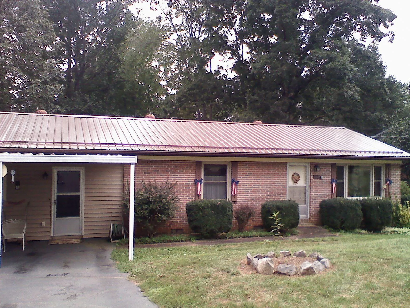 Bronze metal roof and carport on a brick ranch home — Roof Repair work by our crew in Grosse Ile
